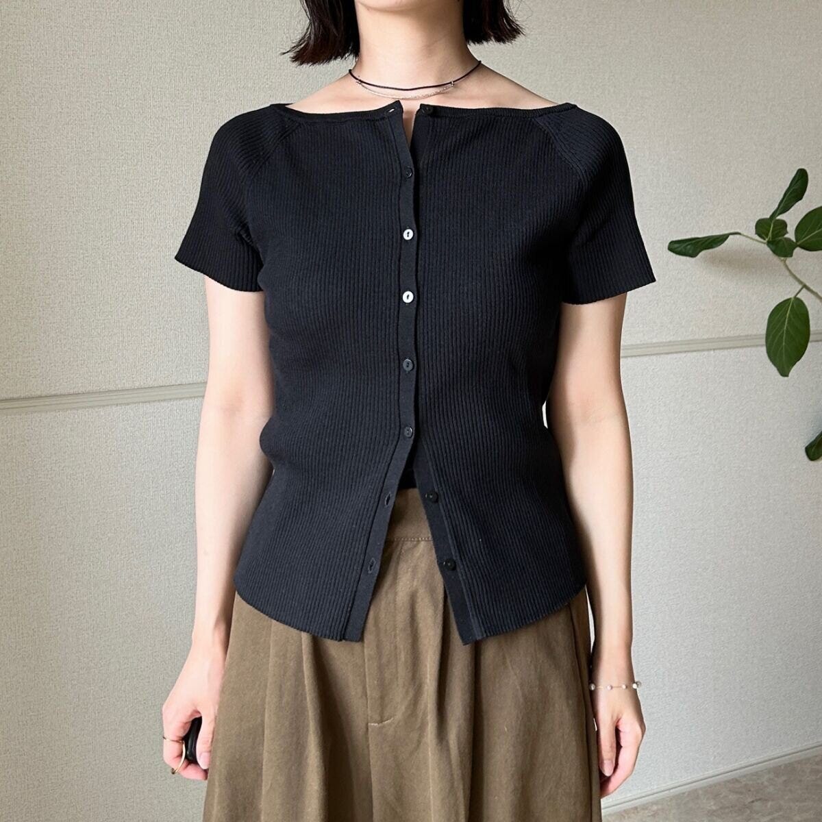 黒カーデとカーキワイドパンツを着た女性の全身 黒カーデとカーキワイドパンツを着た女性の全身