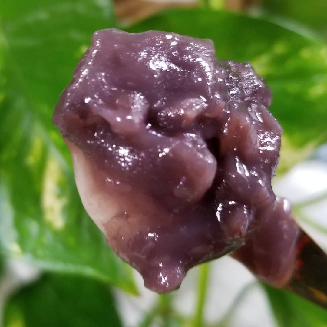 ひとくち白玉の冷やしぜんざいの小豆がかかった白玉をすくっている写真