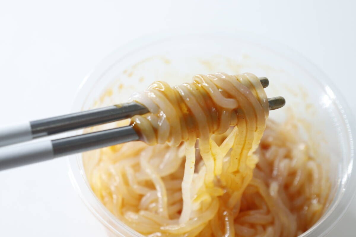 箸で持ち上げられた麻辣湯こんにゃくヌードルのアップ 箸で持ち上げられた麻辣湯こんにゃくヌードルのアップ