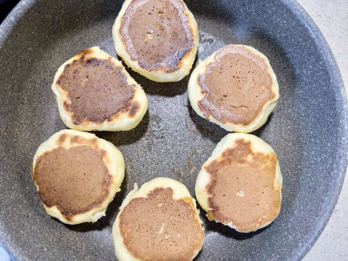 裏返してこんがり焼き色がついた6個のパンがフライパンに並んでいる俯瞰写真