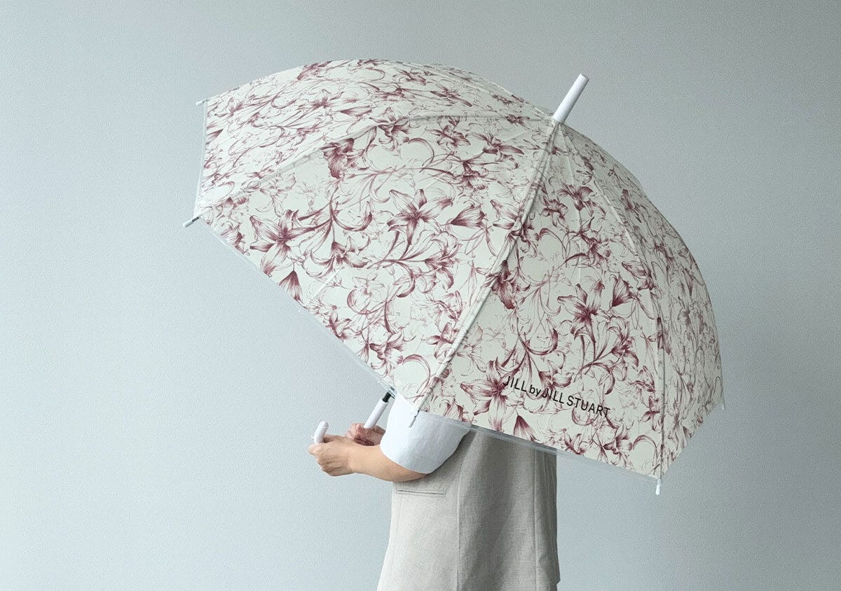 リリーの花柄の傘を差して立っている人物の後ろ姿 リリーの花柄の傘を差して立っている人物の後ろ姿