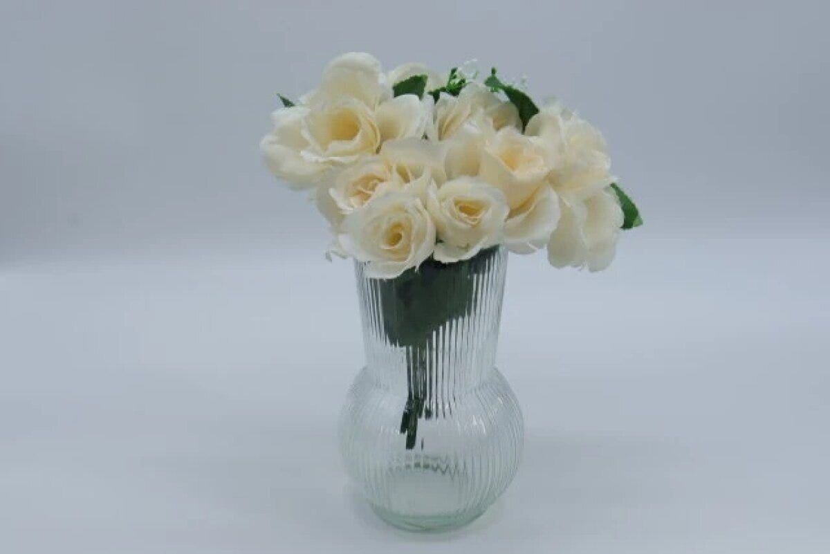 リブ模様のガラスフラワーベースにクリーム色のバラをたっぷり生けた様子 リブ模様のガラスフラワーベースにクリーム色のバラをたっぷり生けた様子
