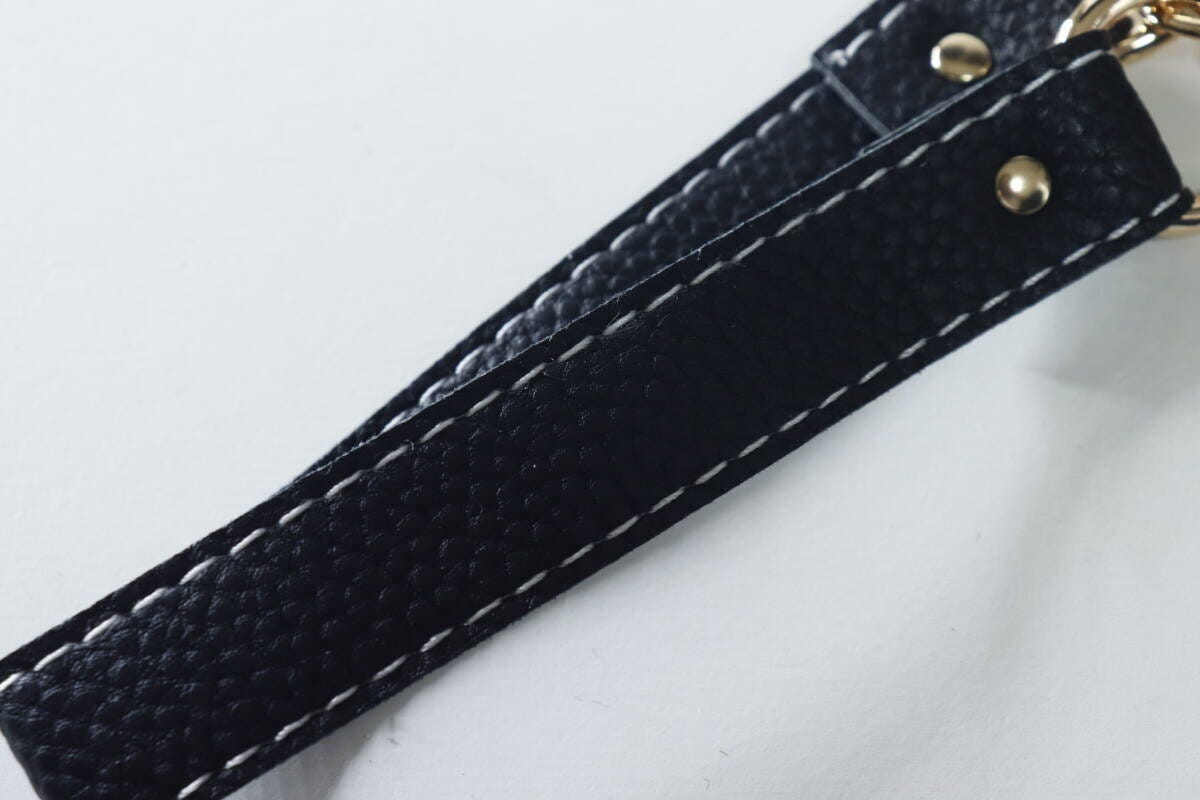 黒い合皮素材のスマホストラップのシボ感と白いステッチ