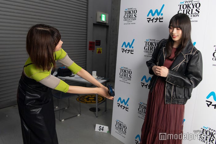 アウターを着用している渡辺梨加を気遣い、手持ち扇風機を当てる渡邉理佐(C)モデルプレス