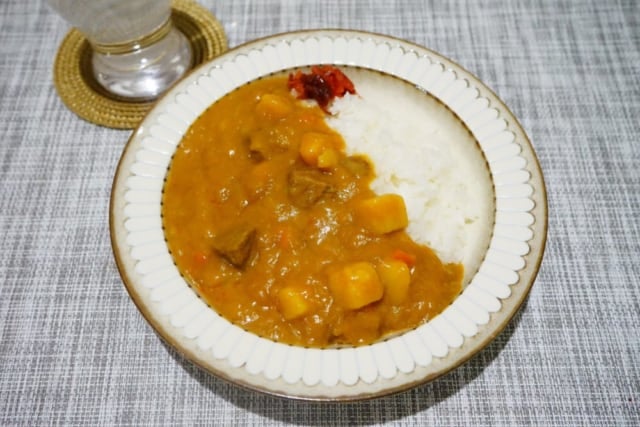白い皿に盛りつけられたカレーライスとグラスの水