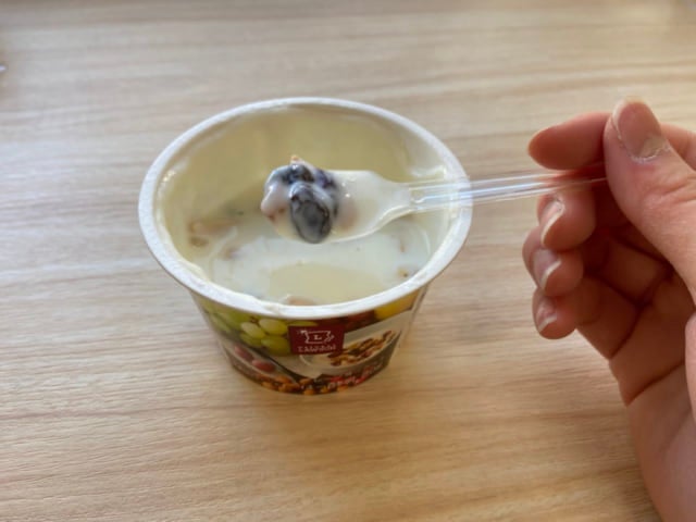 スプーンですくった果実とナッツのヨーグルト