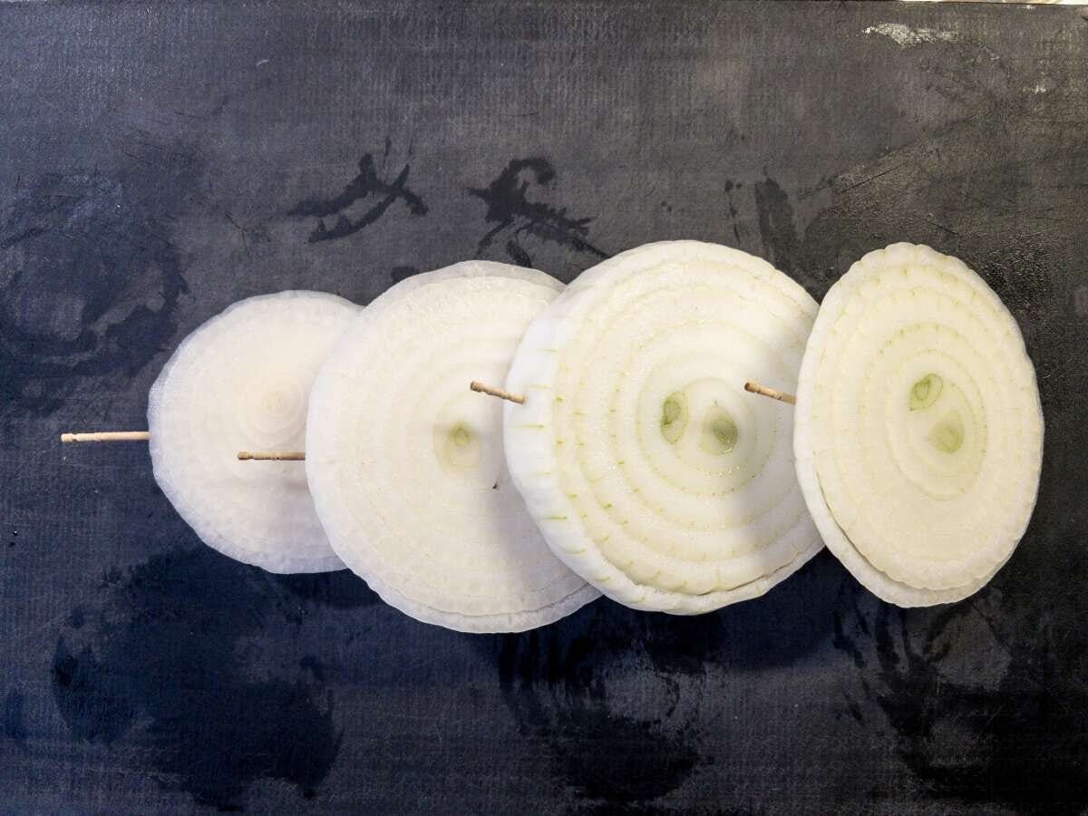 4等分の輪切りにした新玉ねぎに爪楊枝を刺して並べた下準備の俯瞰写真