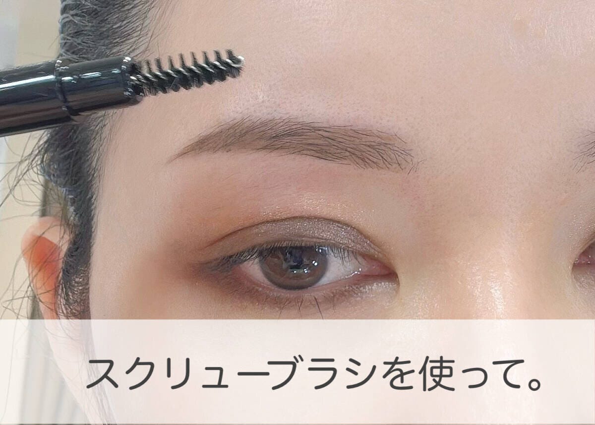 スクリューブラシで眉全体を軽くなじませて整える女性の手元