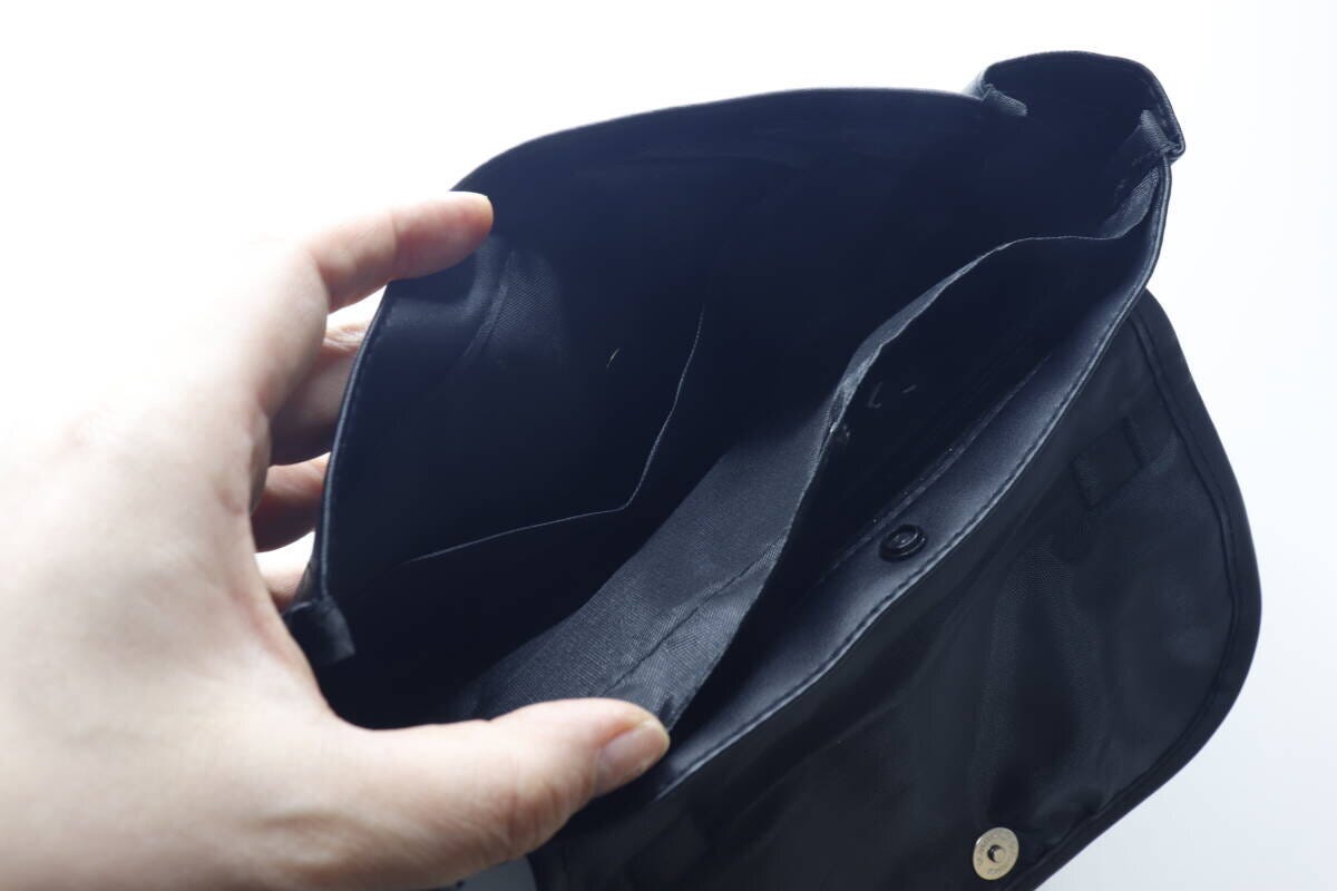 黒いバッグの蓋を開けて内部の仕切りとポケットを見せている