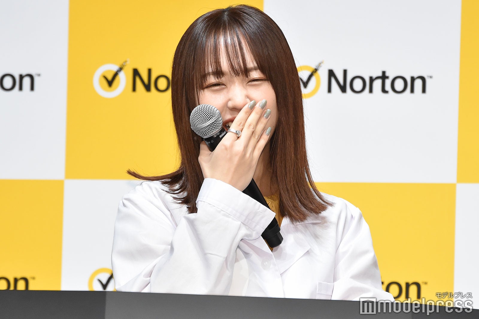 講演台の前で思わず笑ってしまうなえなの（C）モデルプレス