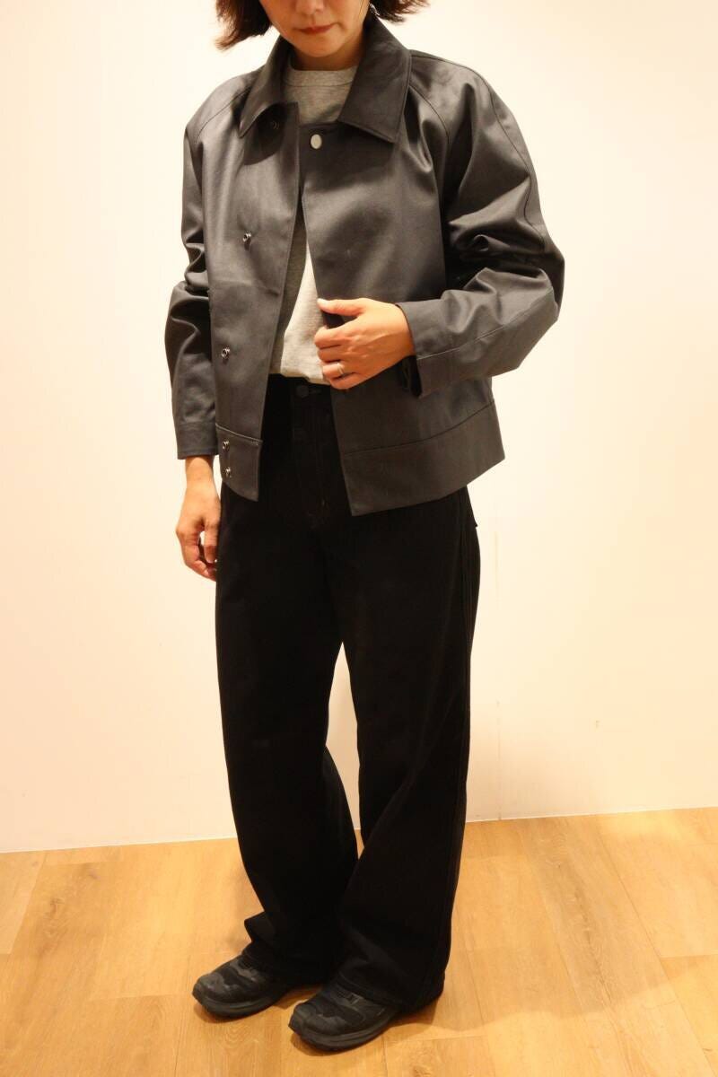 黒のジーンズとグレーのショートジャケットを着た女性