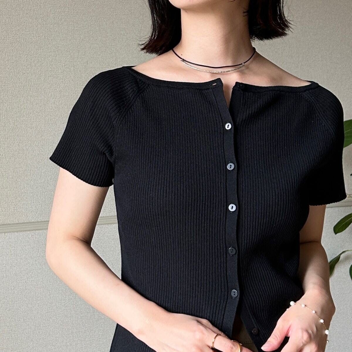 黒カーデのボタンを少し開けた女性の胸元アップ 黒カーデのボタンを少し開けた女性の胸元アップ