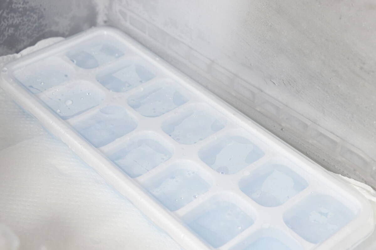 水を八分目まで入れたアイストレーが冷凍庫の棚に置かれている様子 水を八分目まで入れたアイストレーが冷凍庫の棚に置かれている様子