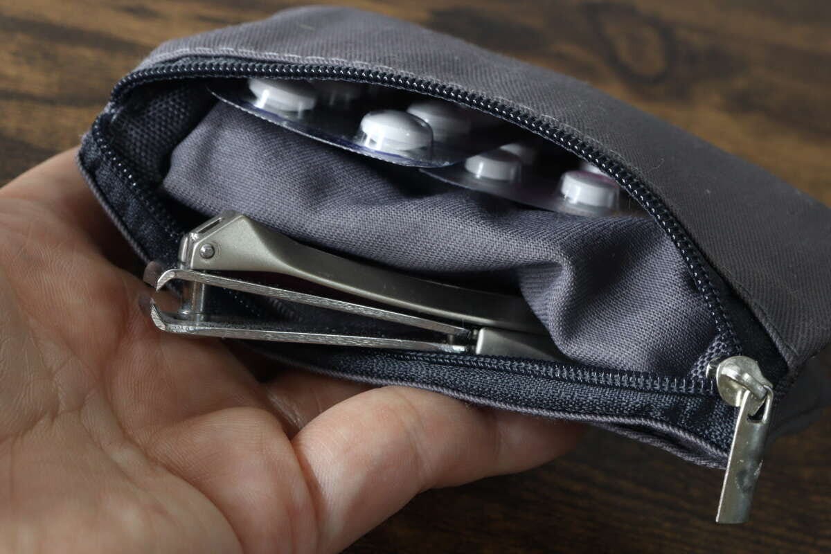 ファスナーポケットの中に錠剤シートと爪切りがすっきりと収納されている状態