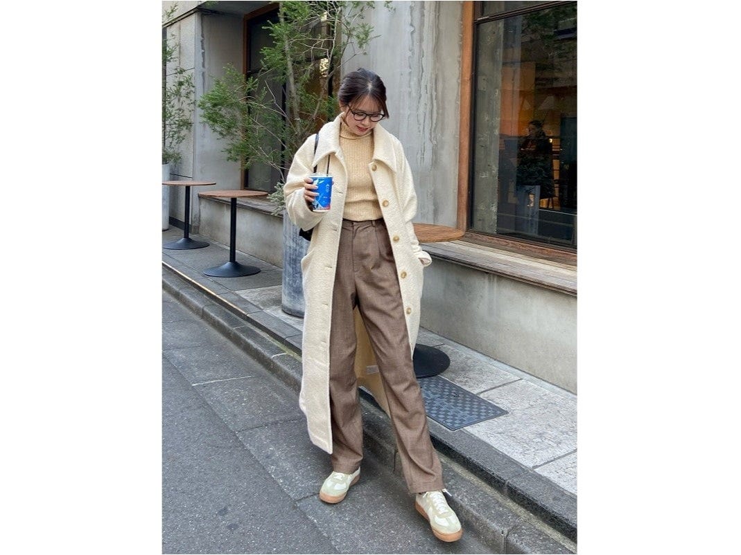 白コートのインナーにはベージュ系のニット＆パンツでグラデカラーに　出典：WEAR