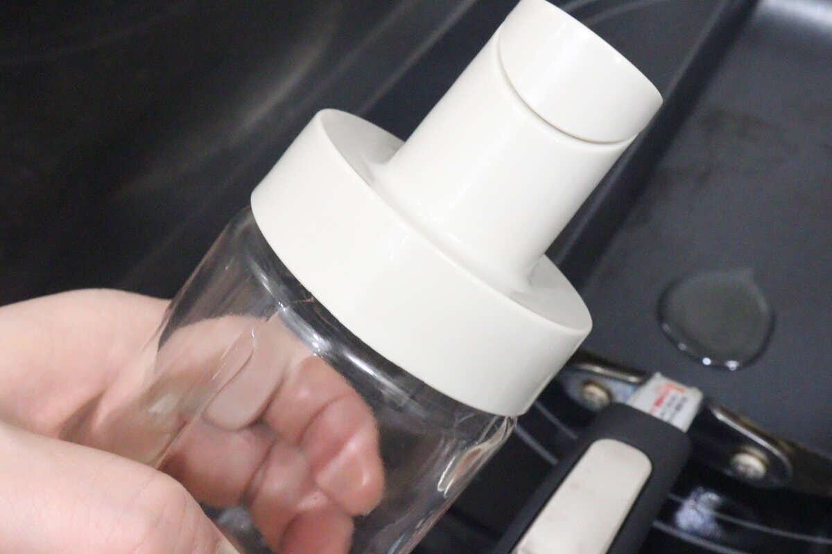 フライパンに油を注ぎ終え、蓋が自動で閉まったオイルボトル フライパンに油を注ぎ終え、蓋が自動で閉まったオイルボトル