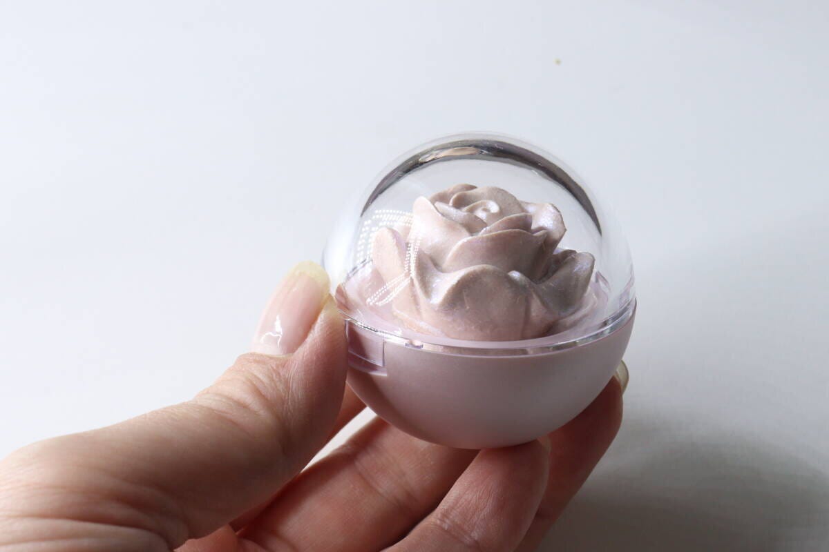 女性の手がバラ型ハイライターのケースを持っている
