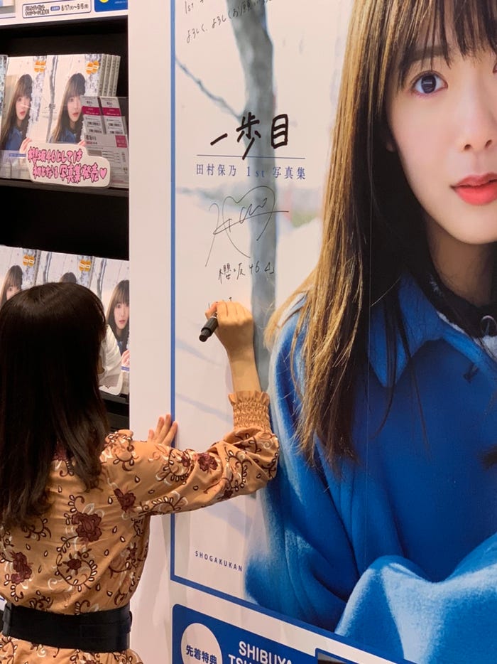 パネル展でサインを入れる田村保乃(画像提供:小学館)