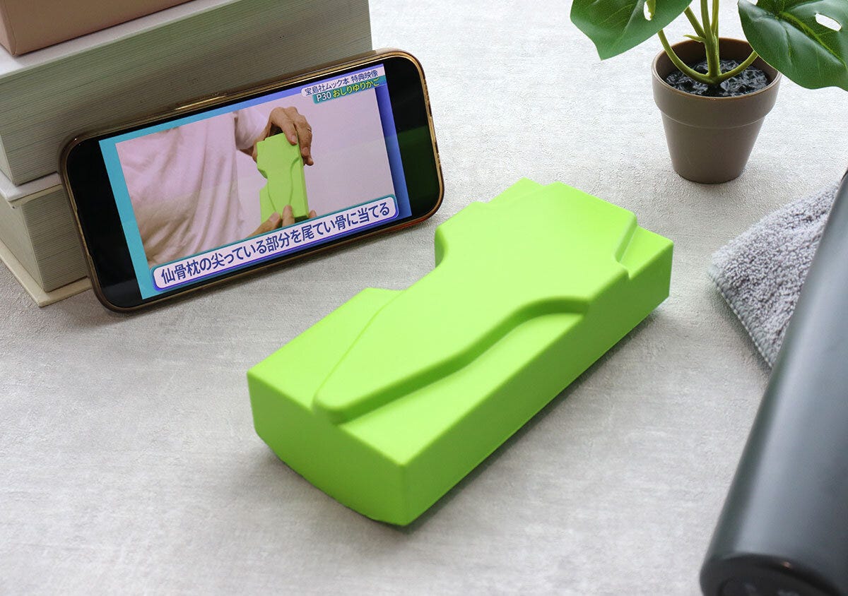 スマホで仙骨枕の解説動画を見ながら使用する様子 スマホで仙骨枕の解説動画を見ながら使用する様子