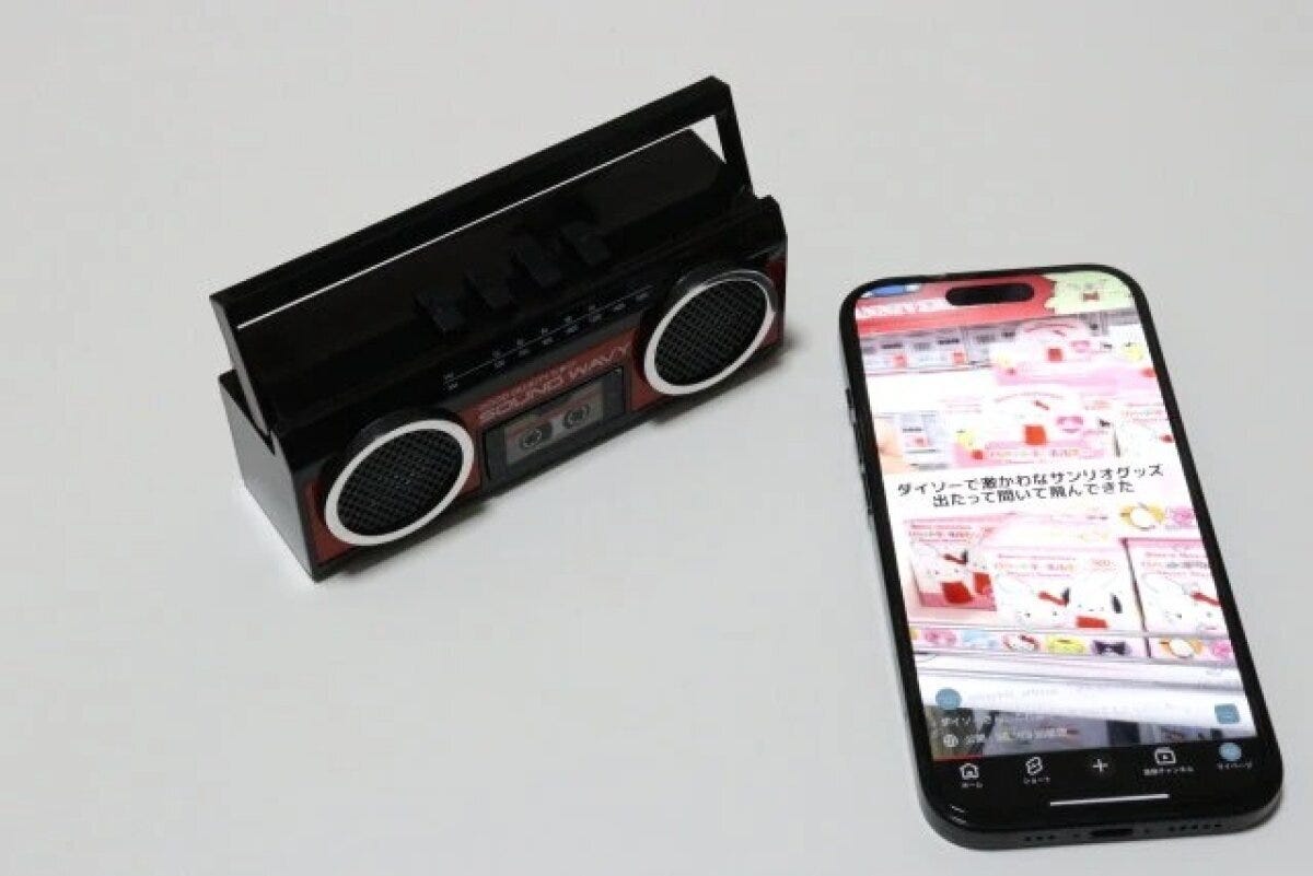 ラジカセ風スピーカーとスマートフォンが並んで置かれている ラジカセ風スピーカーとスマートフォンが並んで置かれている
