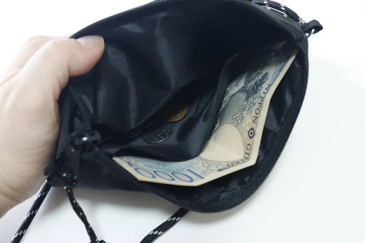 サコッシュのポケットに千円札と小銭が入っている