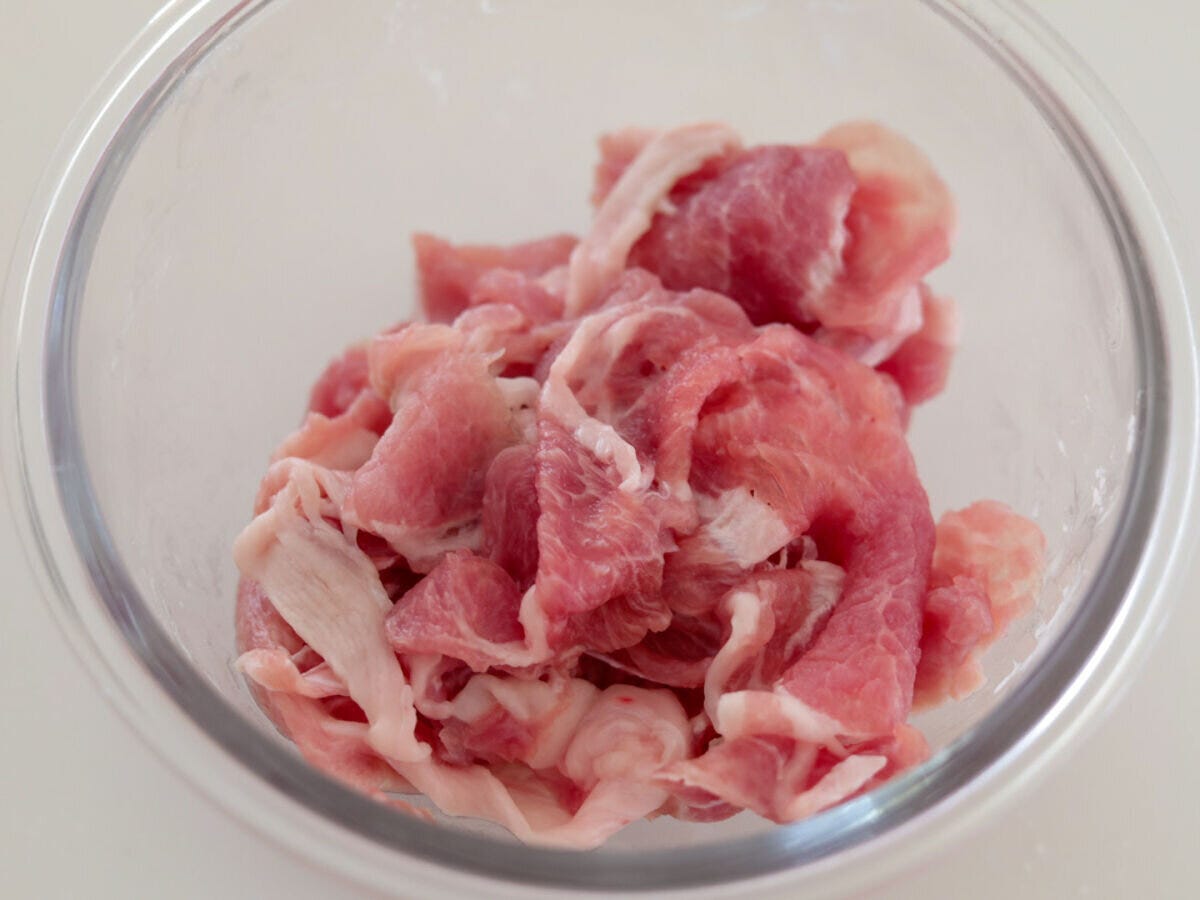 透明なガラスボウルに入った豚こま切れ肉のアップ 透明なガラスボウルに入った豚こま切れ肉のアップ