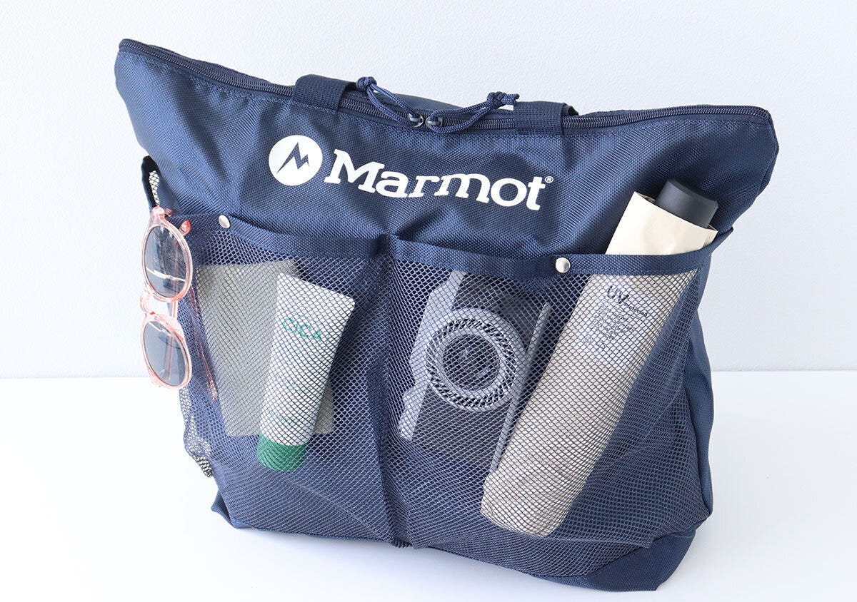 Marmotトートのメッシュポケットにピンクのサングラスとクリームチューブと折りたたみ傘を収納した斜め写真