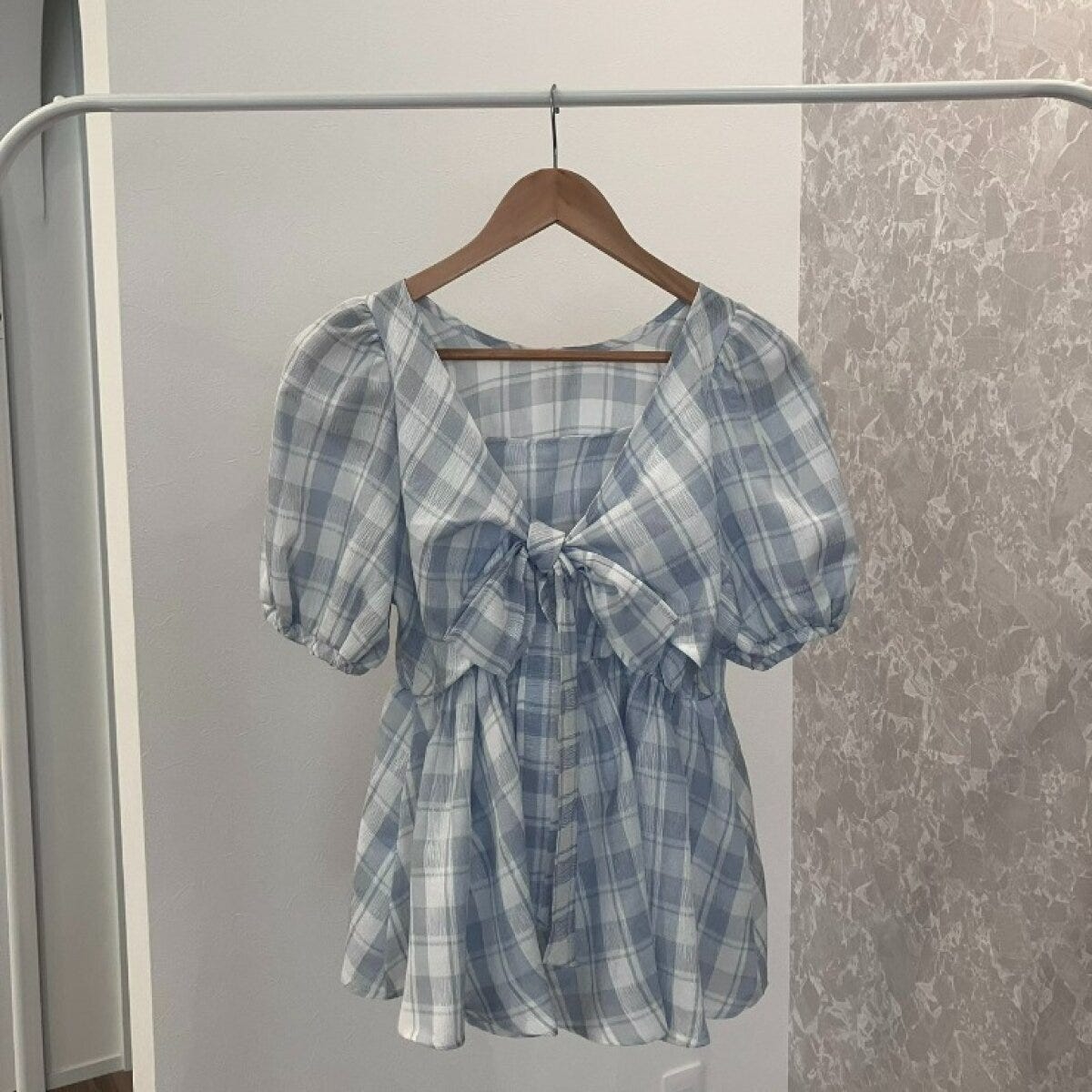 水色チェック柄の前後2WAYブラウスがハンガーに掛かっている 水色チェック柄の前後2WAYブラウスがハンガーに掛かっている