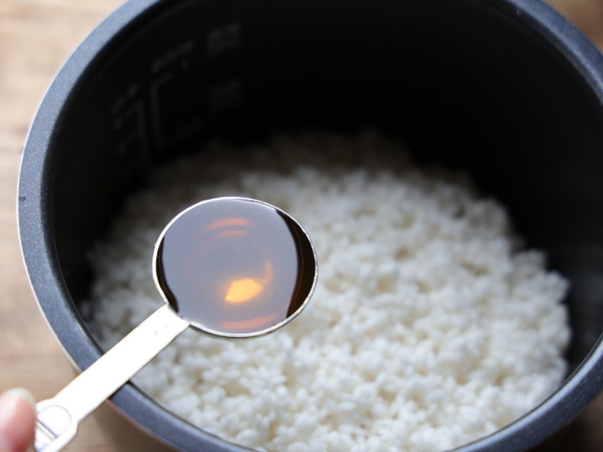 炊飯器の内釜に研いだ米と白だしを入れる工程