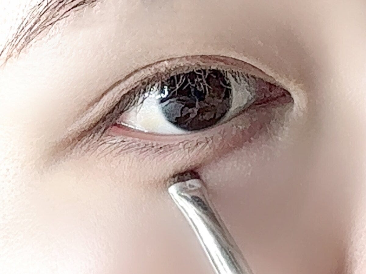 女性の目の下まぶたの涙袋にブラシを当てている様子 女性の目の下まぶたの涙袋にブラシを当てている様子