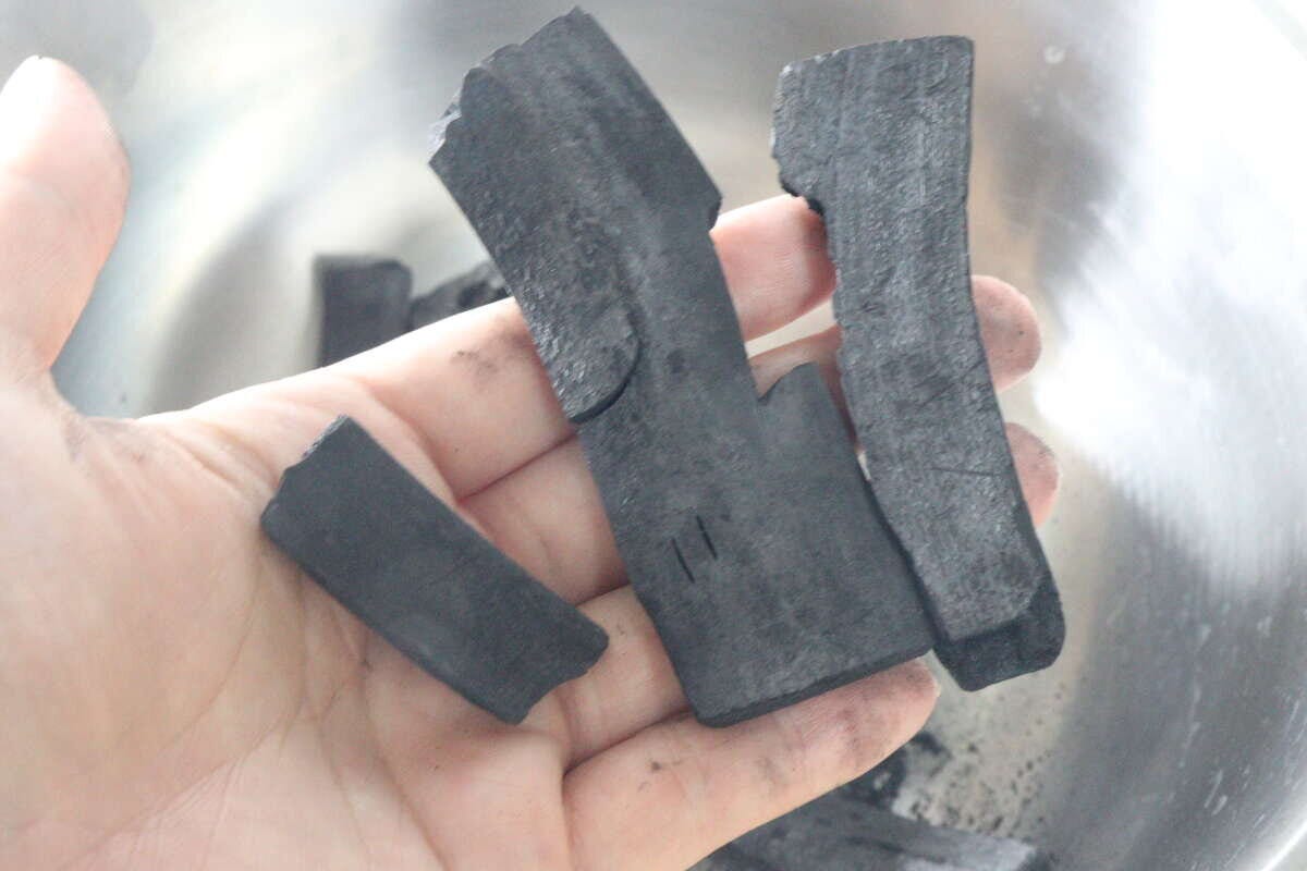 手のひらに数個の竹炭の塊が乗っている様子