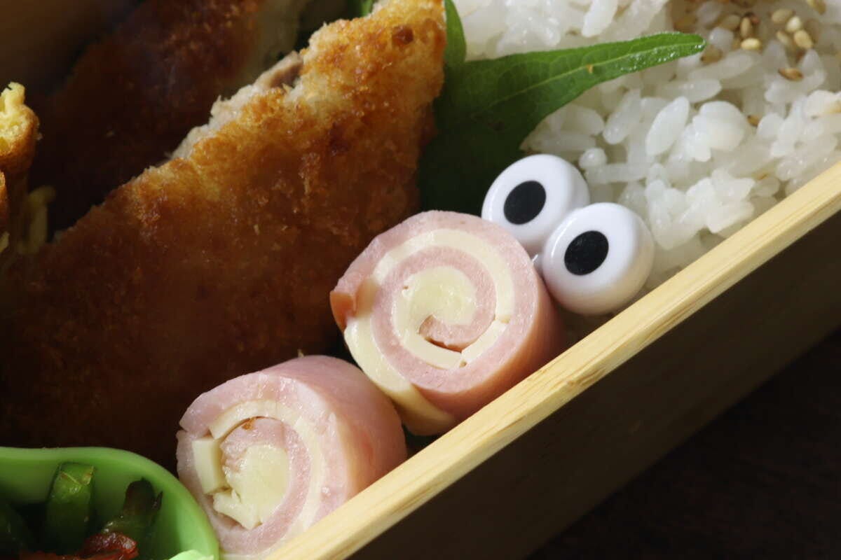 お弁当のハムロールにぎょろ目ピックスが刺さっている お弁当のハムロールにぎょろ目ピックスが刺さっている