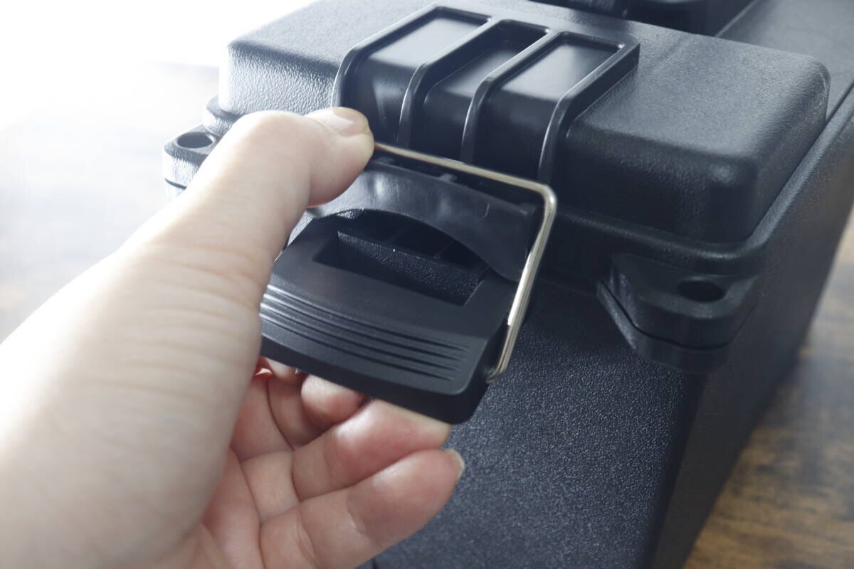 女性の手がダイソー防滴工具箱の頑丈なバックルを外している。