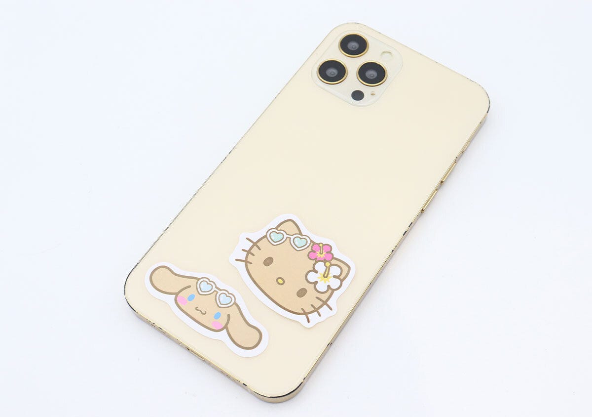 スマートフォンの背面にキティとシナモロールのステッカーが貼られている