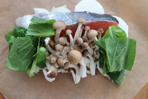 クッキングシートの上に塩・コショウをふった鮭と下処理した野菜をおく。