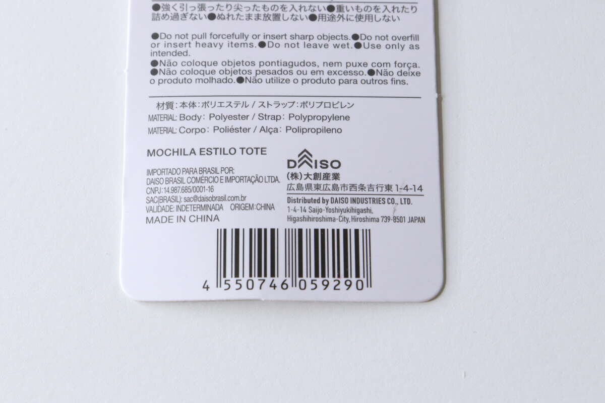 トート型バックパックの商品タグの裏面。バーコード、商品情報、注意書きが詳細に記載されている。