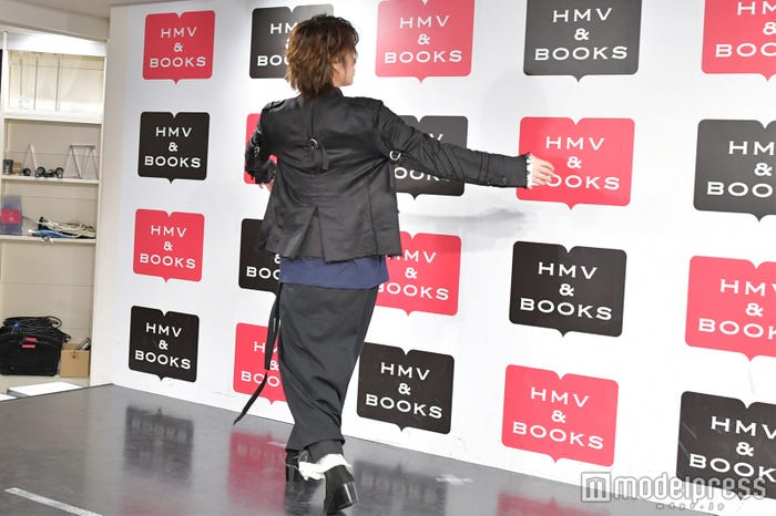 裏表紙の「流」の字の大きさを表現する佐藤流司 (C)モデルプレス