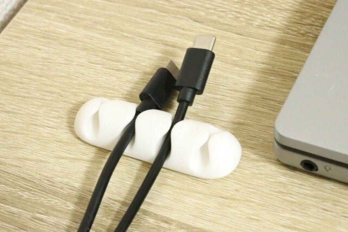 白いケーブルホルダーに黒いケーブル2本が固定されている様子