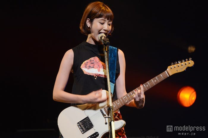 ギターを響かせ、歌声披露