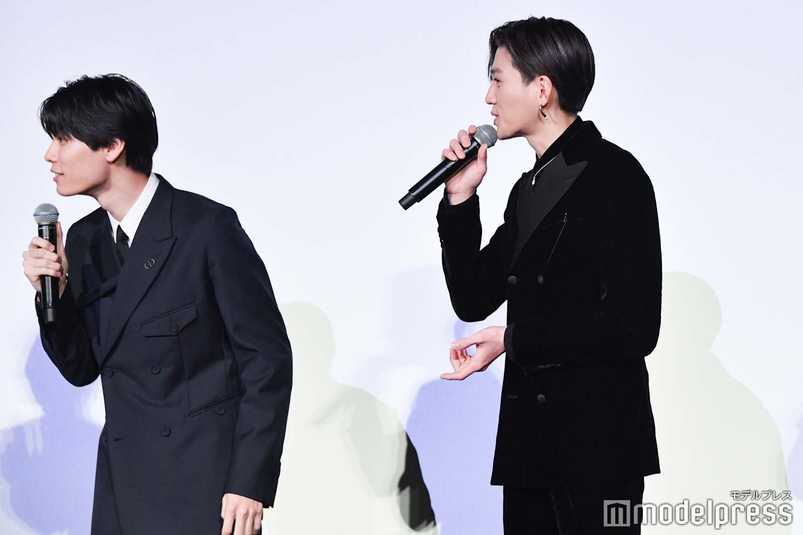 「初給料で買ったもの」を聞かれ、幼少期に母親の手伝いをしてもらったお金が給料に入るか確認する八木勇征（右）（C）モデルプレス