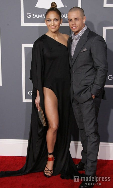 ジェニファー・ロペスはAnthony Vaccarellloの黒のドレスで露出は確かに控えめ!でも、美脚はアピール!!!隣りはアクセサリーの年下恋人キャスパー・スマート。WENN.com / Zeta Image