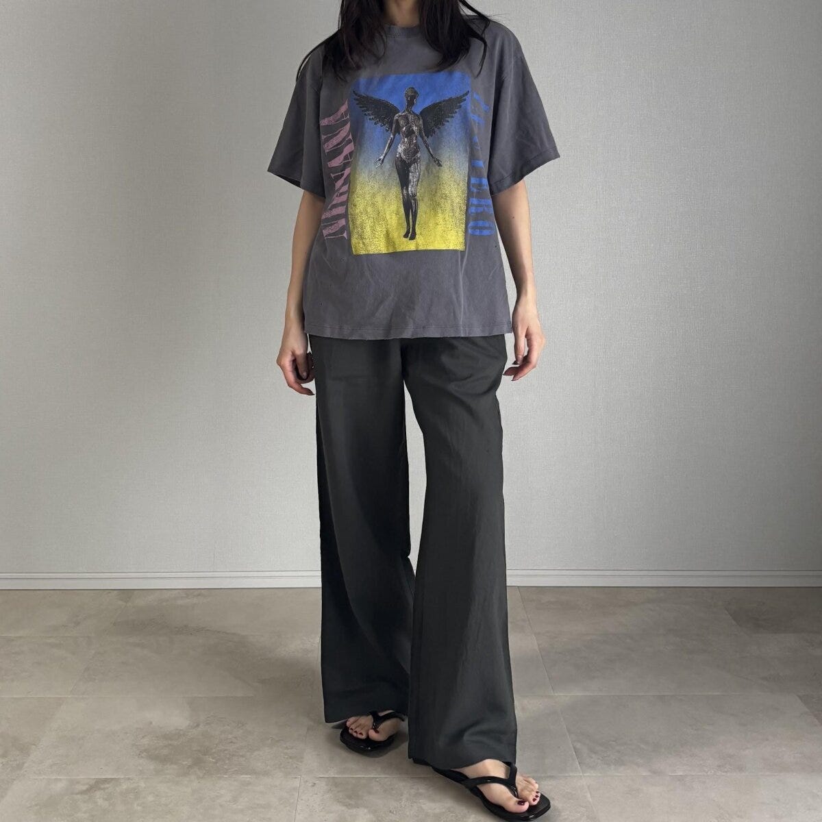グラフィックTシャツとダークグリーンのリネンパンツを着用した女性 グラフィックTシャツとダークグリーンのリネンパンツを着用した女性