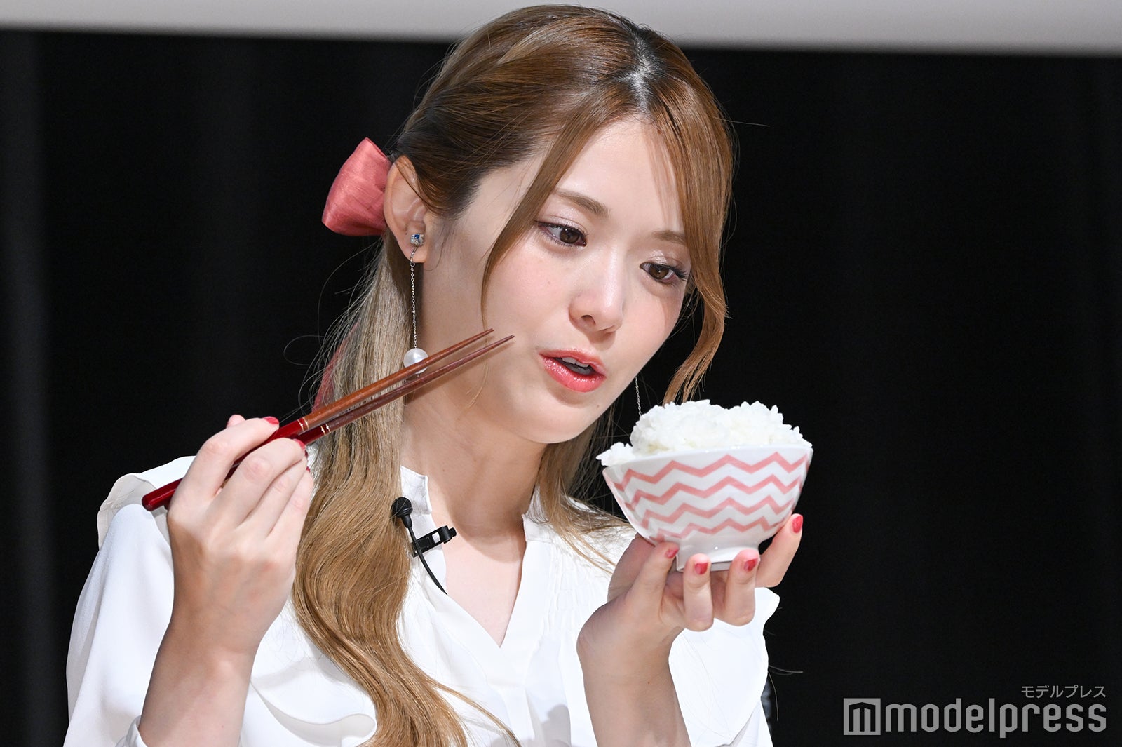 お米をじっくり見つめる松村沙友理 （C）モデルプレス