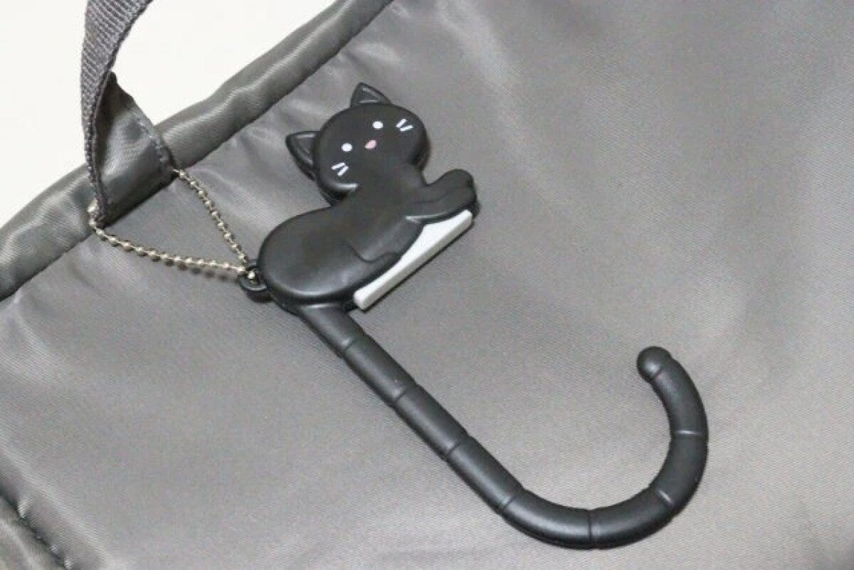 黒い猫型バッグフックがグレーのバッグに付いている