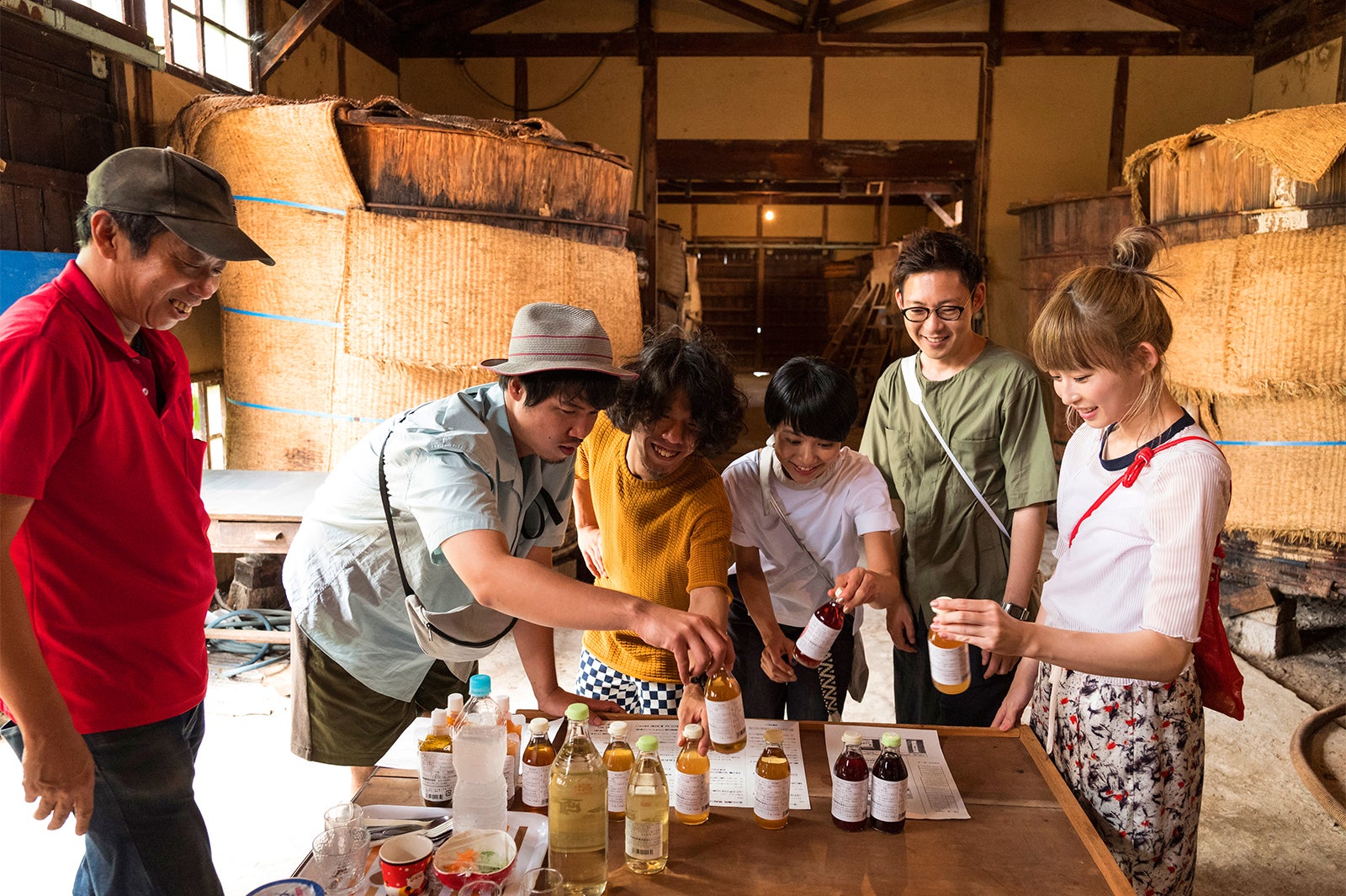 地元の「仁尾酢」醸造所でオーナーから思い入れあるボトルの説明を聞くメンバー（C）Airbnb