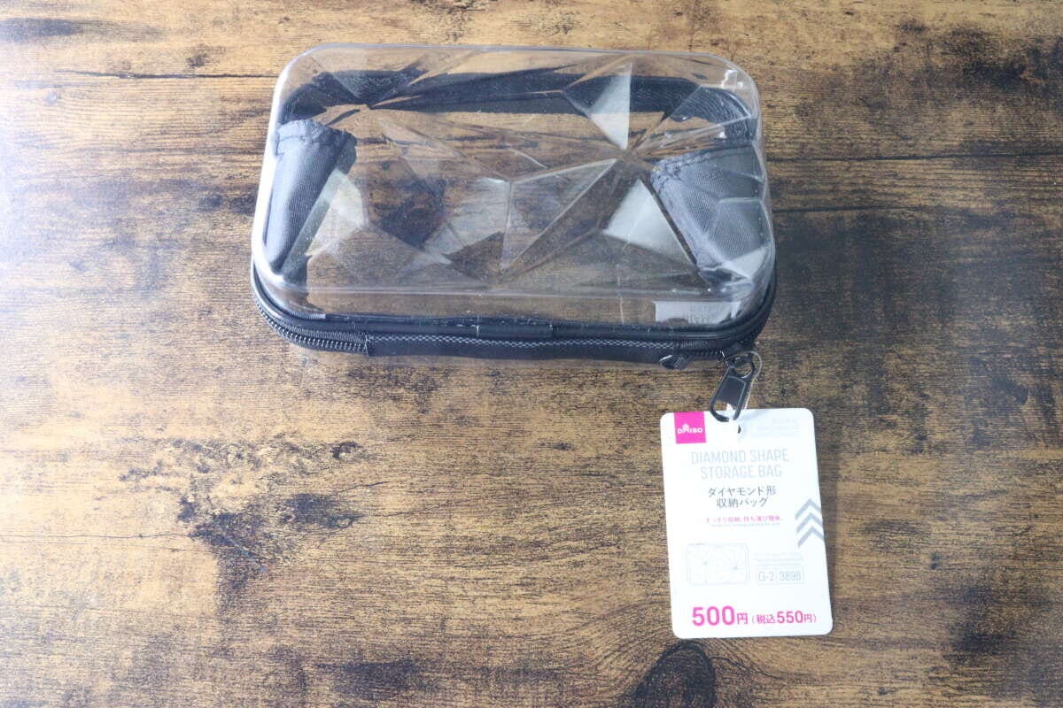 透明なダイヤモンド形収納バッグと商品タグが木目のテーブルに置かれている 透明なダイヤモンド形収納バッグと商品タグが木目のテーブルに置かれている