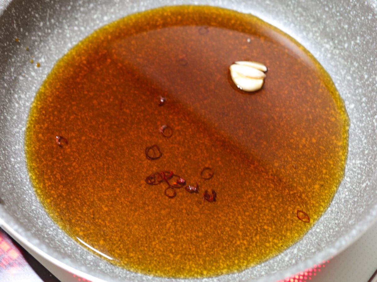 フライパンにしょうゆ、酒、みりん、酢、水、にんにく、赤唐辛子が入った煮汁 フライパンにしょうゆ、酒、みりん、酢、水、にんにく、赤唐辛子が入った煮汁