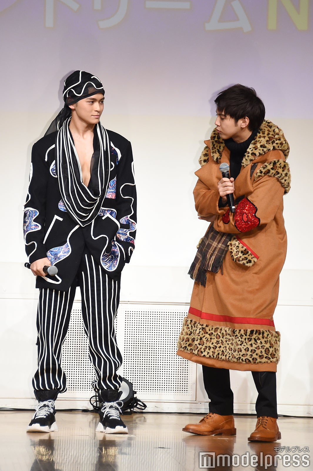 眞栄田郷敦の胸元をチェックする片寄涼太 （C）モデルプレス