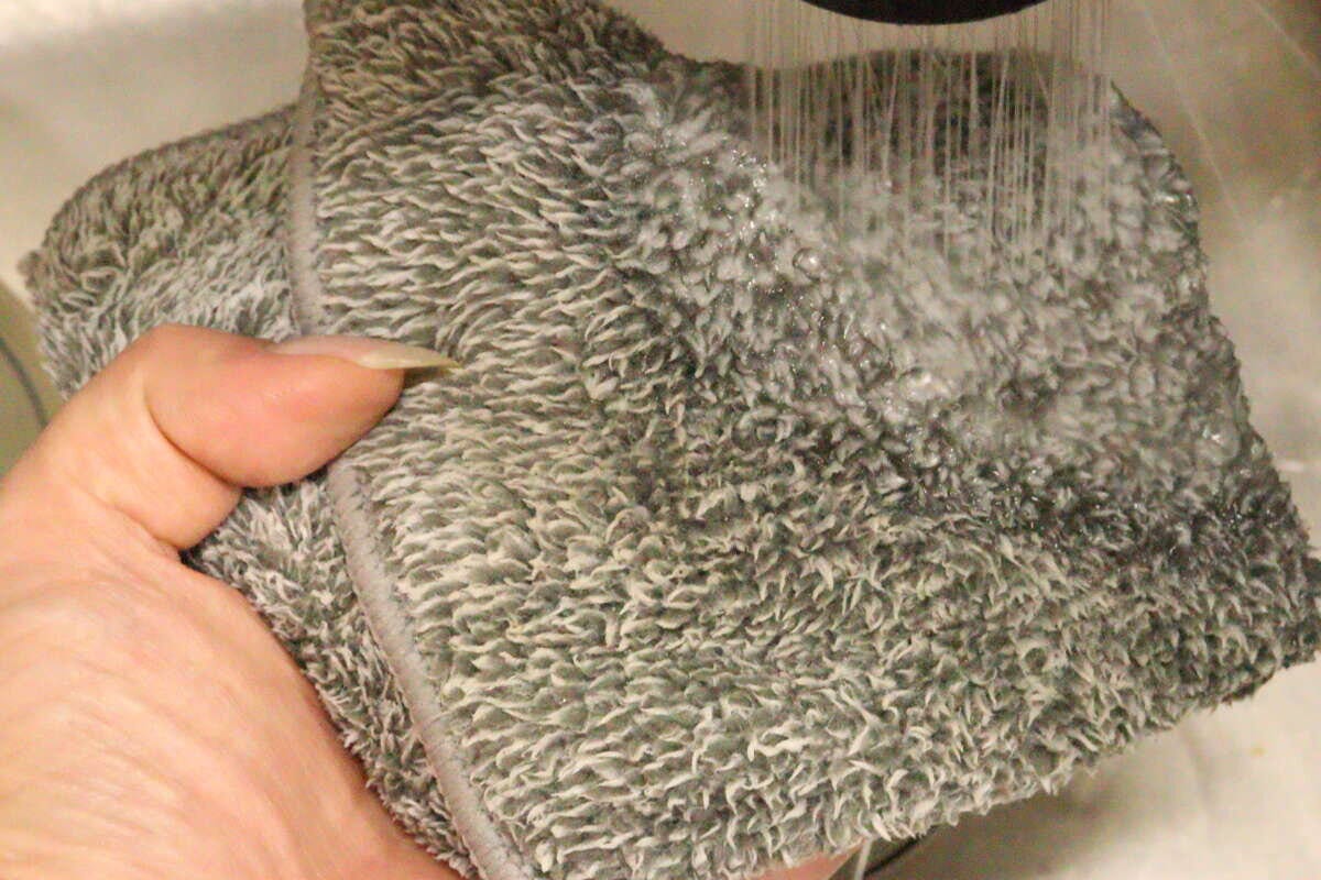 使用後の汚れたふきんを蛇口からの流水で洗い流している様子