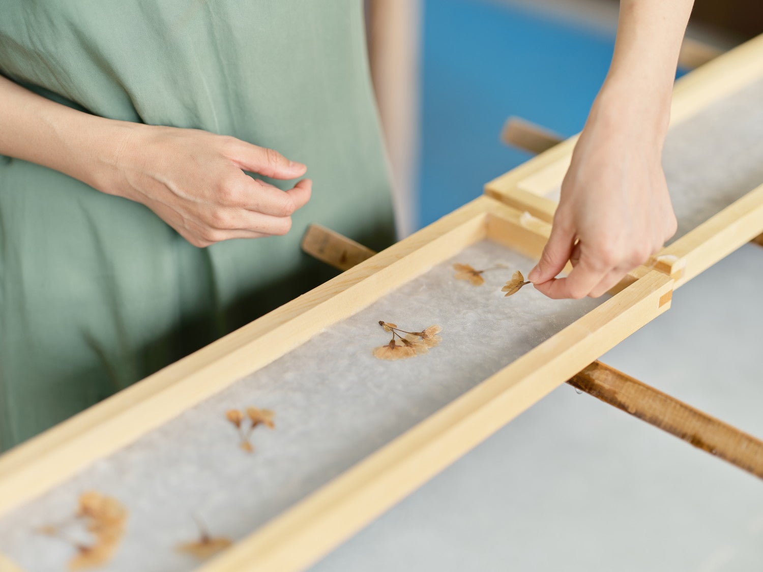 押し花を置いて、和紙にデザインを施していきます／提供画像